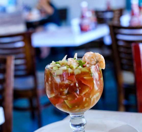 Shrimp cocktail served in a chilled goblet with avocado and cilantro