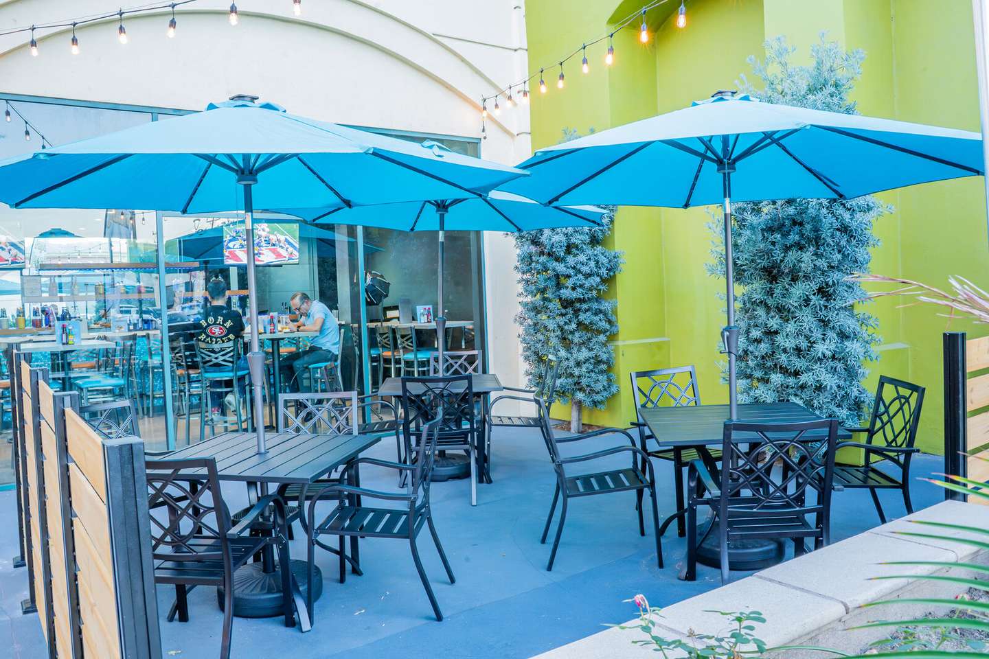 The Papa Juan's patio, outdoor seating under blue umbrellas