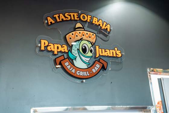 A Taste of Baja sign with the Papa Juan's Baja Grill and Bar logo
